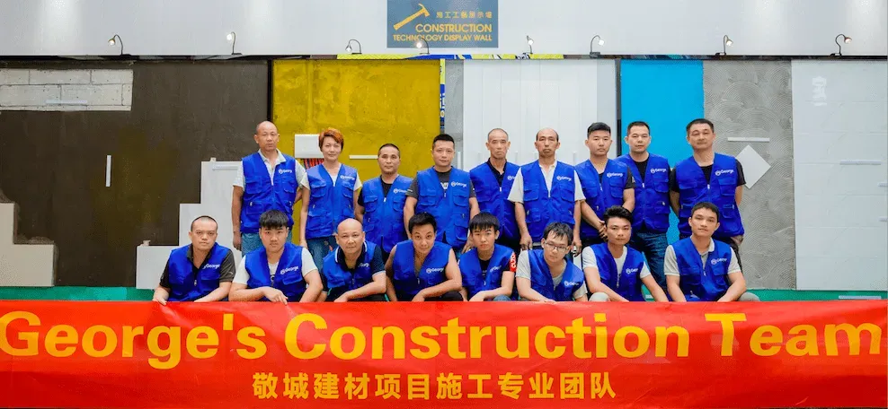 George’s Construction Team group photograph in front of construction material displays.