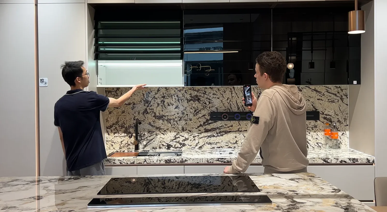 Two people examining cabinet-front and worktop samples in a showroom setting