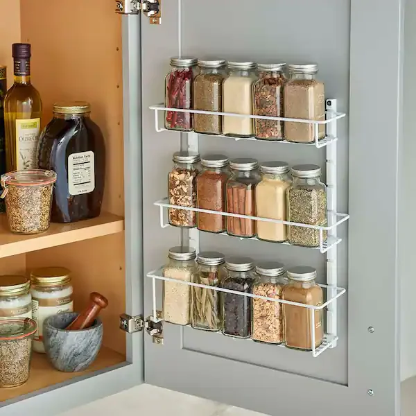 Door-mounted pantry rack holding jars and bottles