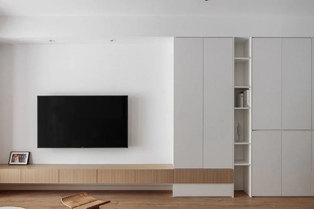 Minimal living-room media wall with base drawers and tall side storage