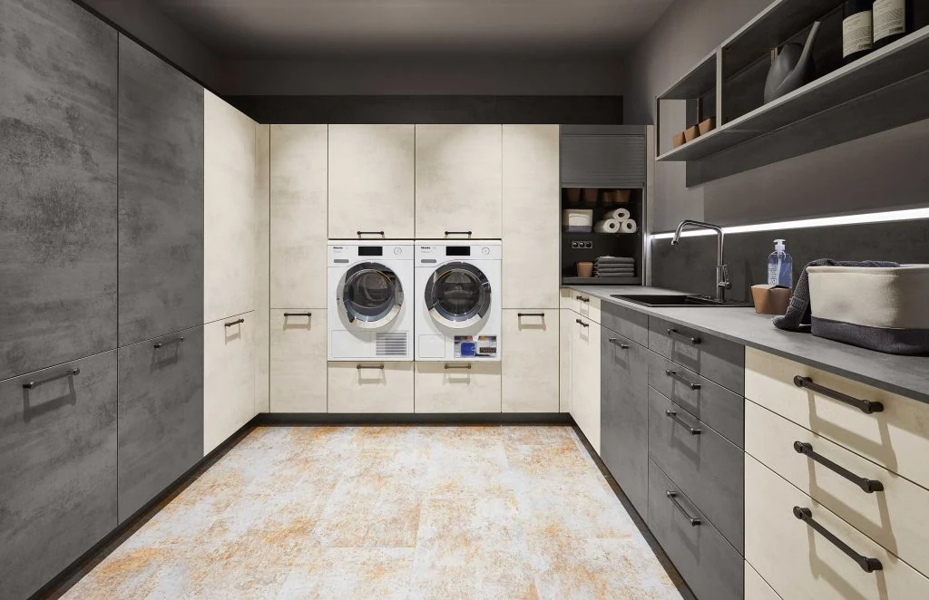 GEORGE Group laundry cabinetry example with two front-loading machines, drawers, tall cabinets and a worktop