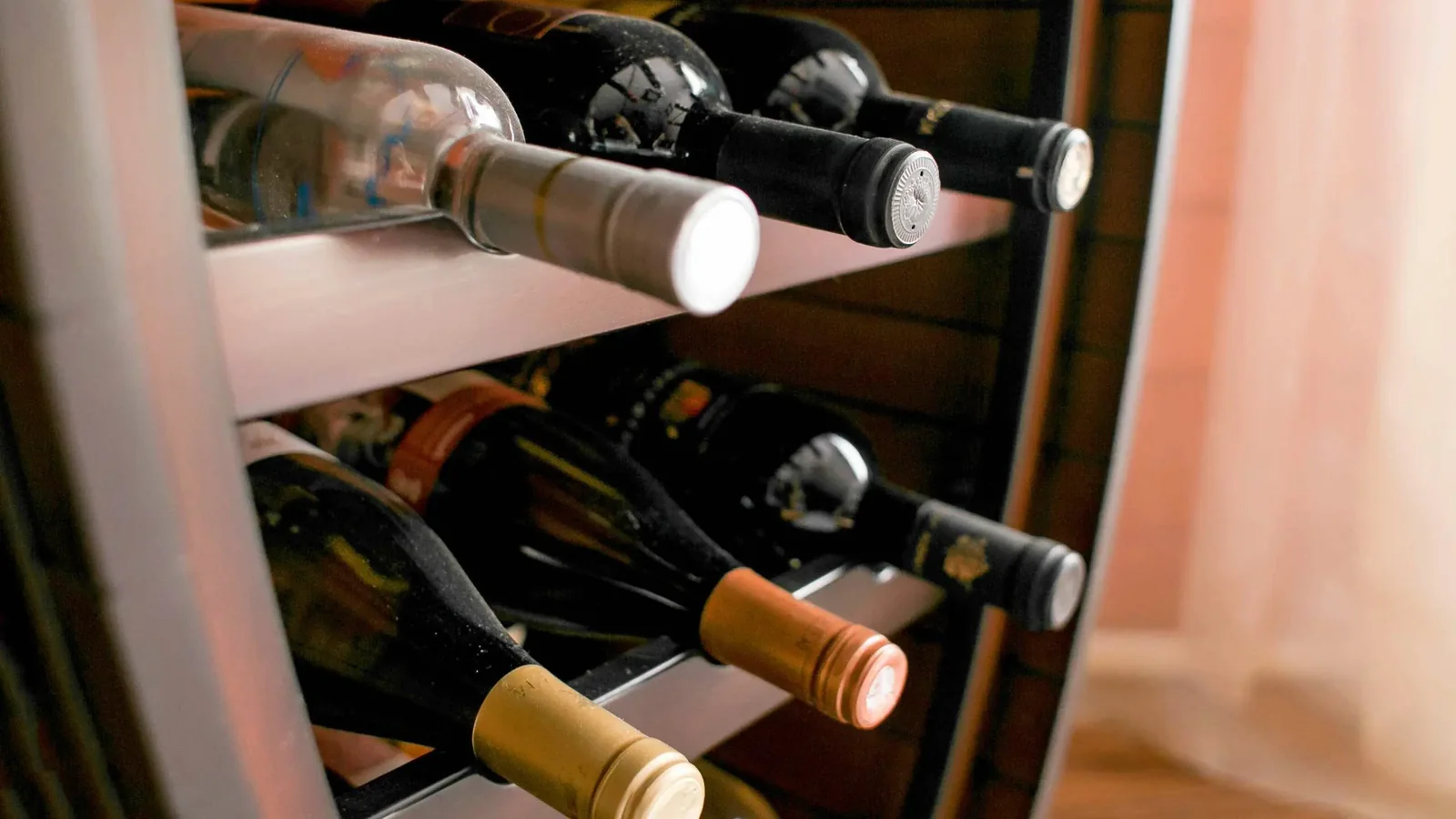 Angled bottle racks storing wine bottles inside a cabinet